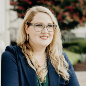 Headshot of Noel, who is a white woman with long blonde hair and glasses.